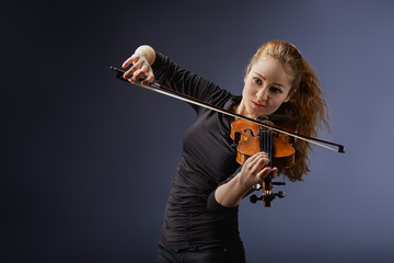 Beautiful young woman playing violin. Portrait of musician