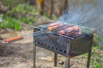 Pork steaks and grill on the burning fire