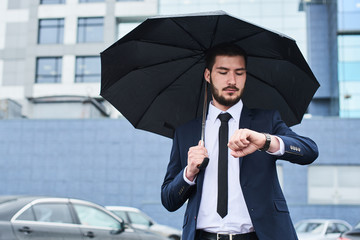 The guy in the suit on the Parking lot with an umbrella in the hands of your watch