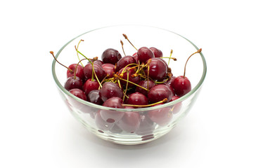 Glass bowl full of cherries isolated