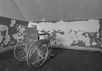 Old wheelchair in corner of room