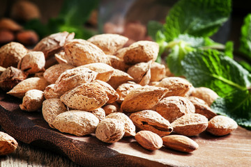 Almonds in shell, vintage wooden background, selective focus