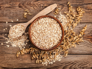 oatmeal in a bowl and spoon old board on top. Spikes of oats - 109086649