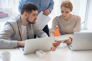 team of three coworkers in stylish studio