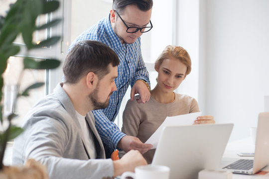 team of three coworkers in stylish studio