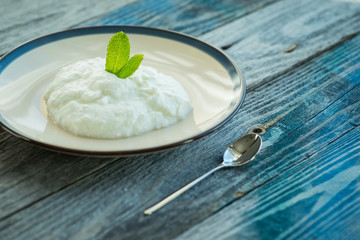 Plate with fresh yogurt on wooden table
