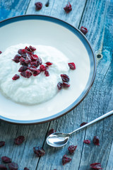 Plate with fresh yogurt on wooden table