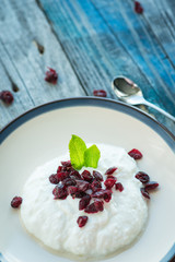 Plate with fresh yogurt on wooden table