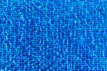 Water surface background in blue swimming pool outdoors
