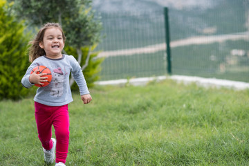 runnign child in garden with ball