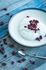 Plate with fresh yogurt on wooden table