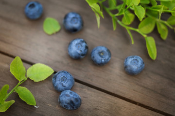 Fresh ripe blueberries outdoors on a wooden background