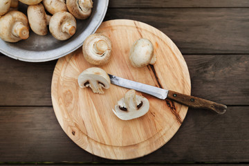 Fresh champignon mushhrooms on a wooden background