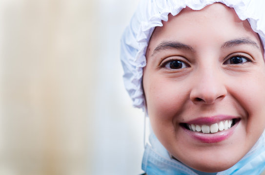 Closeup Headshot Female Nurse Wearing Bouffant Cap And Smiling Happily For Camera