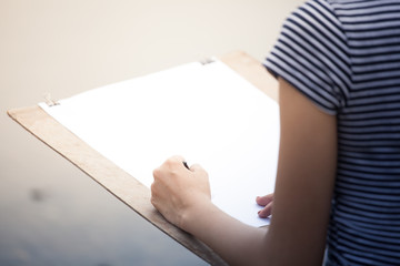Artist girl drawing something in a paper