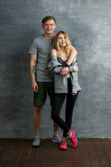 Two beautiful friends, man and girl, smiling in a gym