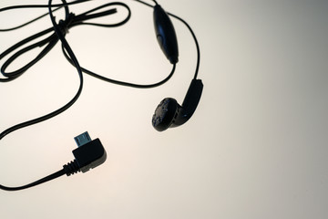 Black Headphones and Cables on White Uplit Background