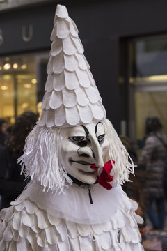 Ein einzelner, als weisser Clown mit Spitzhut verkleideter Teilnehmer der Basler Fasnacht 2016.