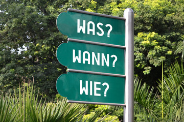 Was? Wann? Wie? Signpost in German.