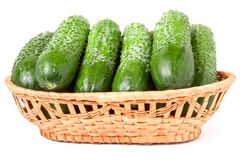 cucumbers in a wicker basket isolated on white background