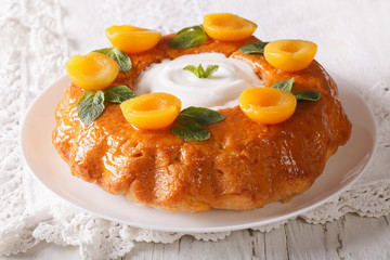 Tasty cake Savarin with apricots and mint close-up. horizontal
