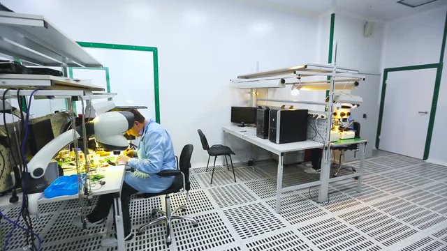 Two Engineers Sitting at Their Workstations and Learn the Details of a Microscope Lab Live Cam