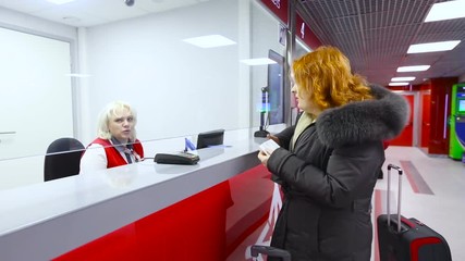 Woman Middle Age With a Bag Buying a Ticket at Red the Box Office and the Cashier Show Direction Railway Airport