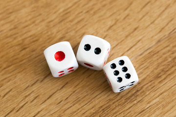 Photo of three white dices being rolled on wooden background