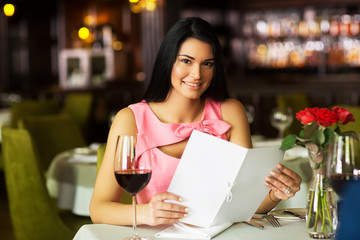 beautiful young girl making an order in a restaurant, in the hands of the menu girls