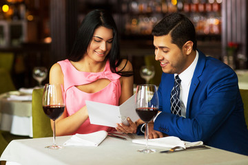 Cheerful couple with menu in a restaurant making order