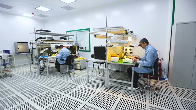 Two Engineers Sitting at Their Workstations and Learn the Details of a Microscope Lab