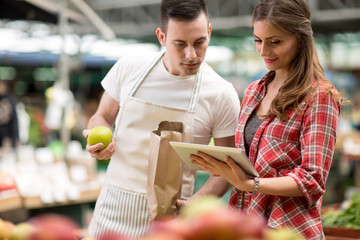 salesman and customer looking checking list in the market ..