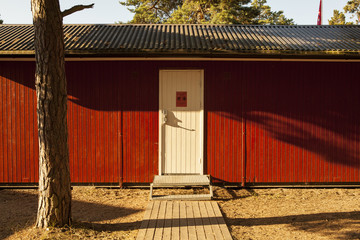 red wooden beachhouse with white door at a beach in sweden