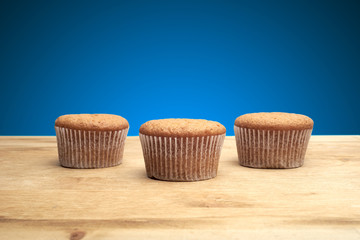 Three cupcakes on a wooden table