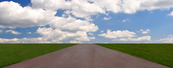  road through the green field and clouds on blue sky