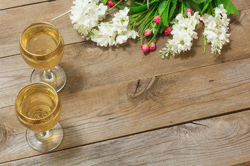 Two glasses of white wine and flowers