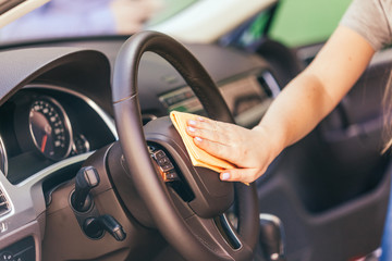 Hand with microfiber cloth cleaning car