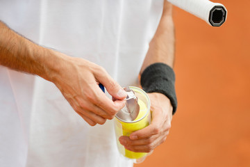 New balls. Tennis player opening can with new tennis balls
