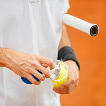 New tennis balls. Tennis player opening a can with new tennis balls