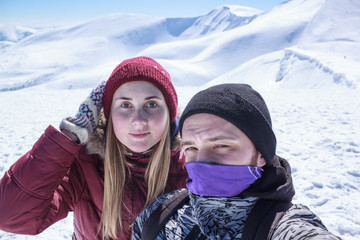 Fototapeta na wymiar man and woman doing selfie in the snowy mountains