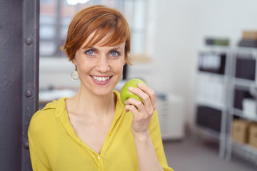frau isst obst in der pause im büro