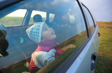Fototapeta premium little girl in the car smiling
