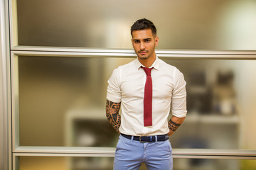 Tattooed young male office worker standing