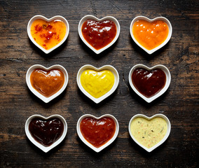Nine colorful sauces and marinades in heart shaped bowls