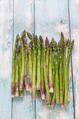 Fresh green asparagus on wooden background, top view, vertical