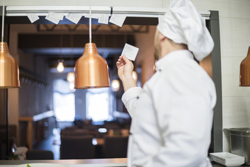 Rear view of chef taking orders