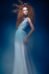 Beautiful fashionable red-haired girl in  transparent dress,  mermaid image with creative hairstyle curls. Fashion beauty style.