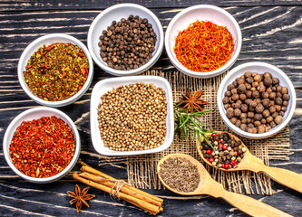 Colorful aromatic Indian spices and herbs on an old oak wooden brown background  