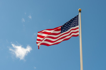Bandiera Americana che sventola sul pennone nel cielo azzurro