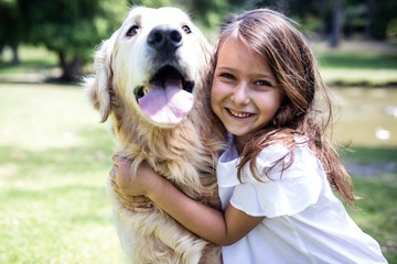 Smiling girl with her pet dog in the park